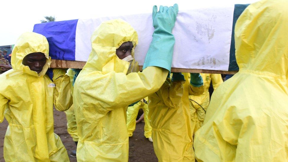 Men disembark coffins of mudslide victims from a truck on August 17, 2017 at Waterloo cemetery near Freetown,