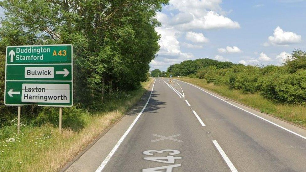 A43 road and street sign indicating directions for Bulwick, Laxton, Harringworth, Stamford and Duddington