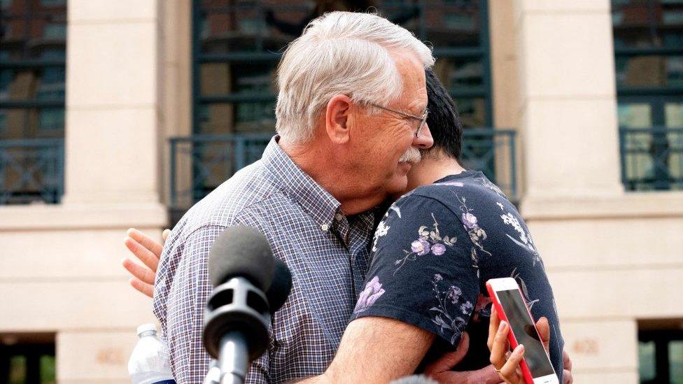 Carl Mueller, father of late US aid worker Kayla Mueller, hugs her friend after a jury convicted El Shafee Elsheikh on terrorism charges