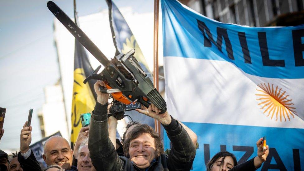 Presidential candidate Javier Milei of La Libertad Avanza lifts a chainsaw next to Buenos Aires province governor candidate Carolina Piparo of La Libertad Avanza during a rally on September 25, 2023 in San Martin, Buenos Aires, Argentina.