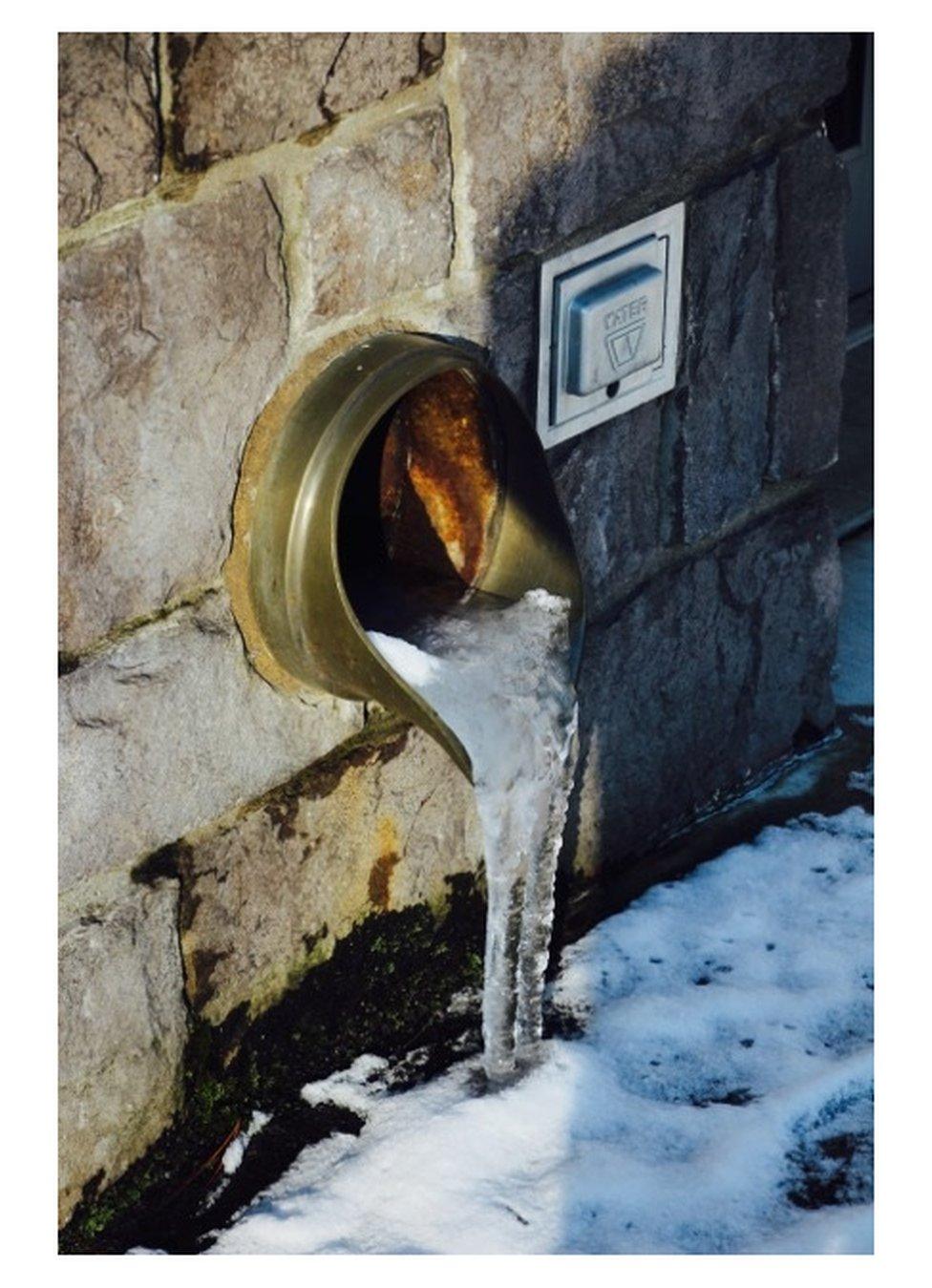 Frozen water coming out of a pipe