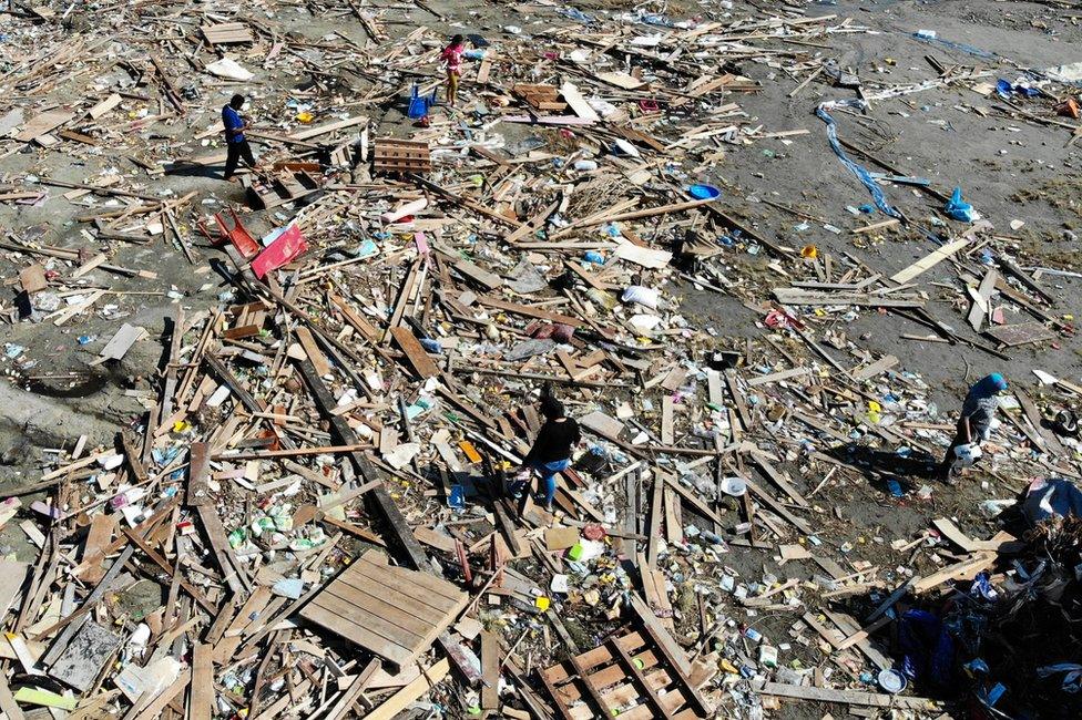 Overhead view of people looking through debris in Palu