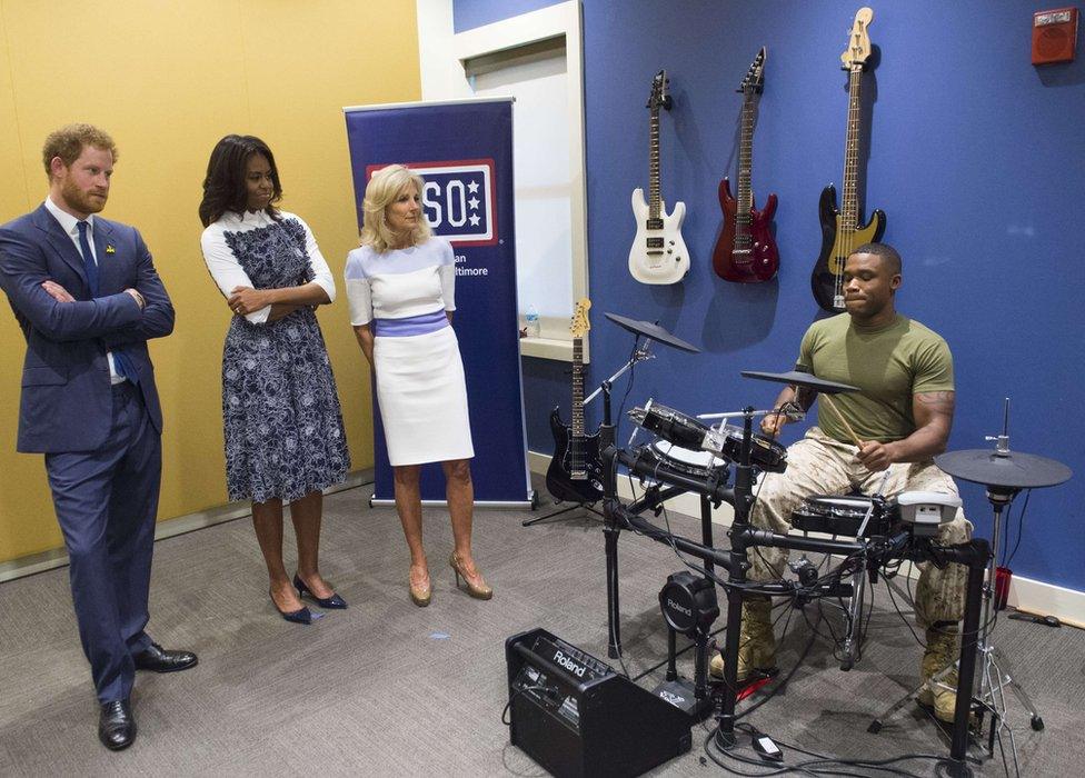 Prince Harry, Michelle Obama and Jill Biden listen to Sgt. Roderic Liggens perform on the drums