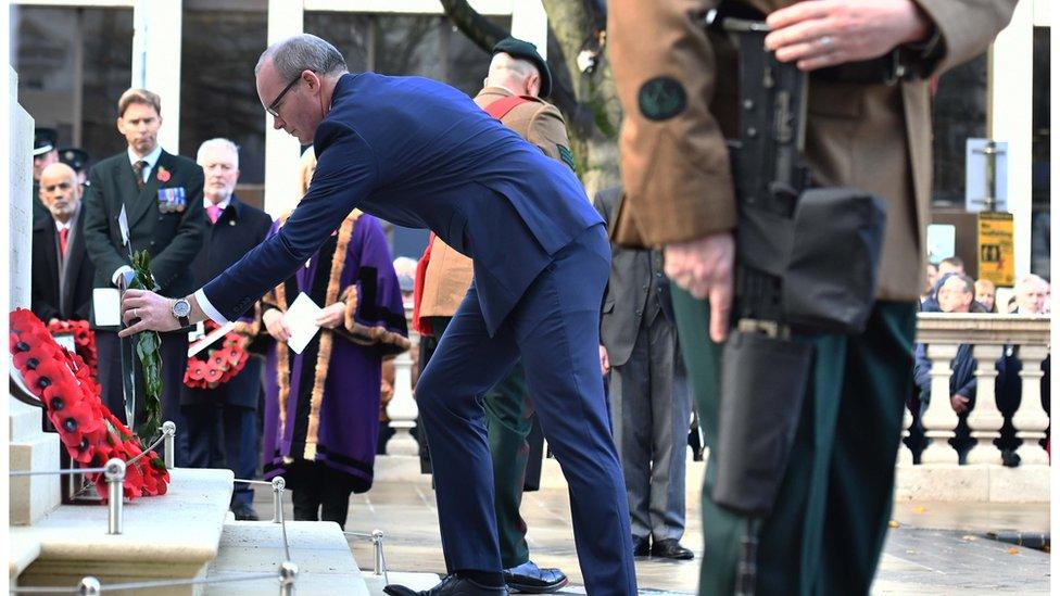 Simon Coveney laying a wreath during the remembrance ceremony in Belfast