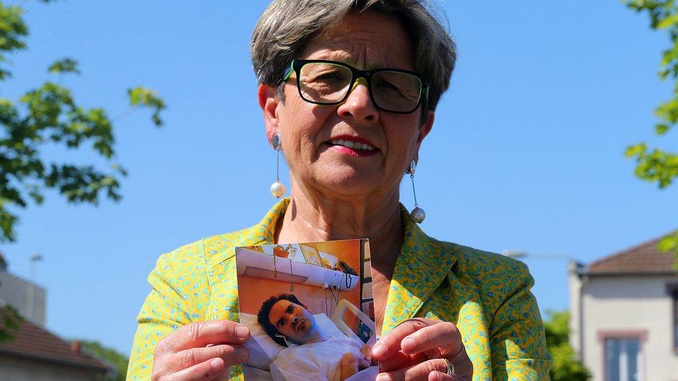 Viviane Lambert, the mother of Vincent Lambert, poses with a photograph of him in hospital