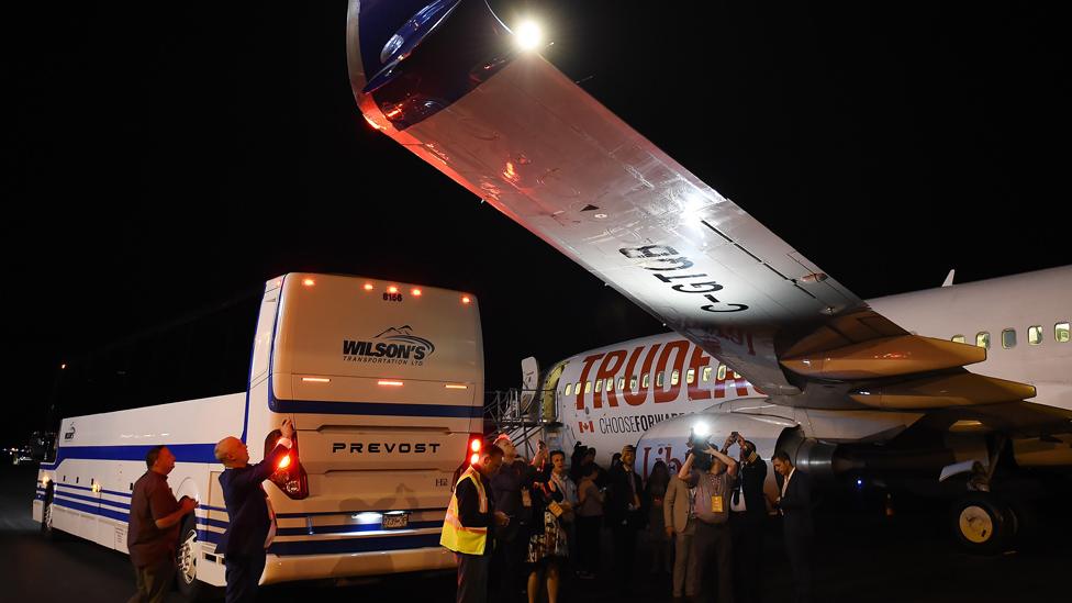 Members of the media and others inspect the damage on the plane's wing.