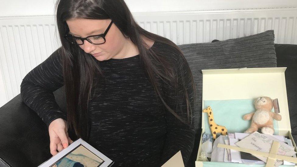 Kayleigh Atkins looking at a photo of her stillborn son