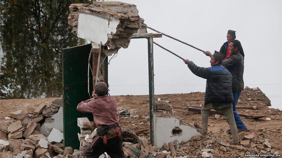 A group of villagers demolish a damaged house by the earthquake in Dhunche village, Rasuwa district, Nepal