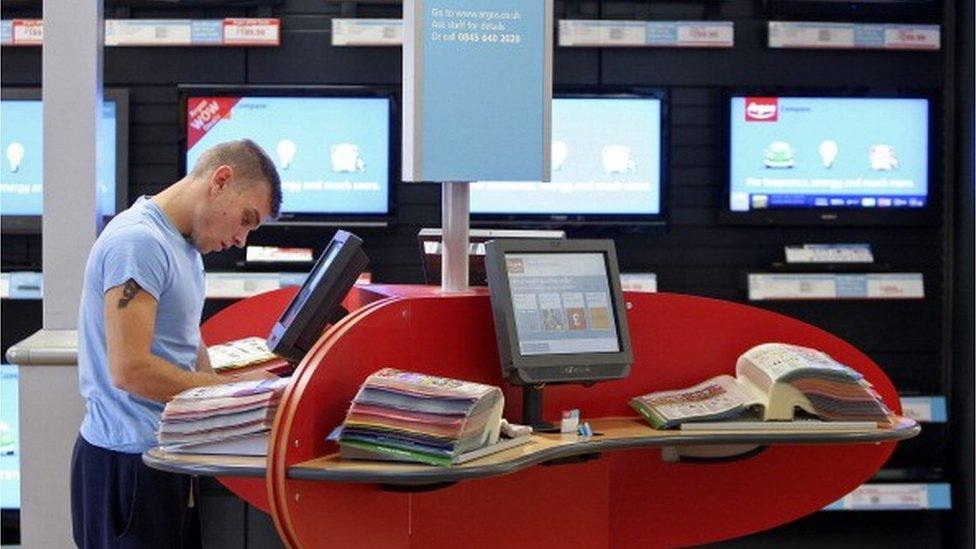 A customer browses a catalogue at an Argos store,