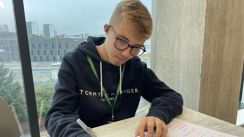 A student, Hayden, studying for his maths exam in a classroom at his college