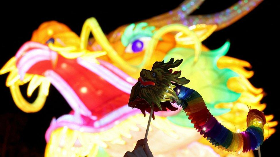 A performer holds a replica of dragon during a show of the Chinese Lunar New Year