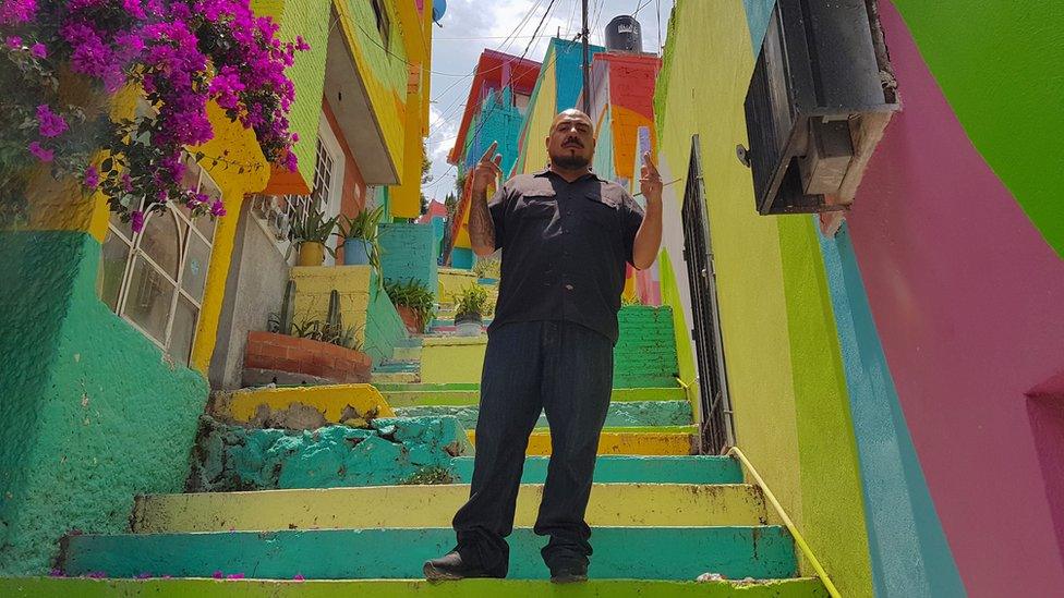 Enrique Gómez poses in a colourful alley in