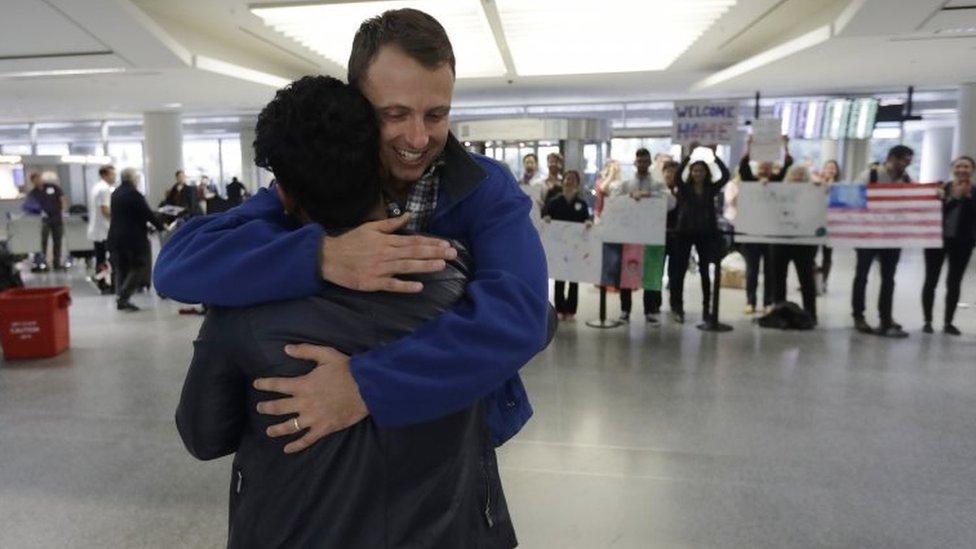 Army Capt. Matthew Ball, right, hugs his former interpreter Qismat Amin at Sa Francisco International Airport.