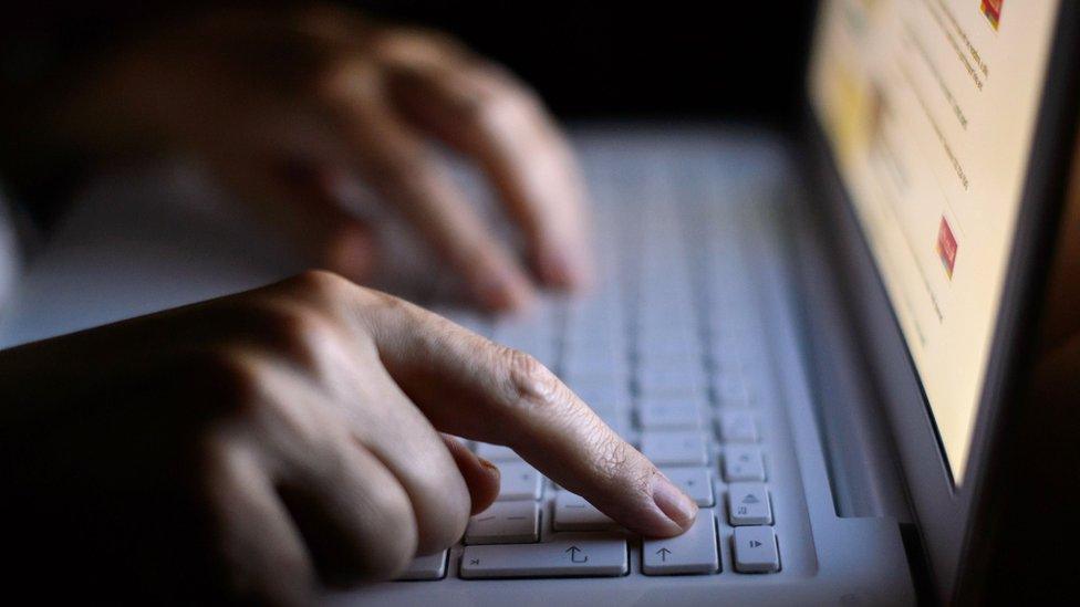 Hands typing on laptop keyboard