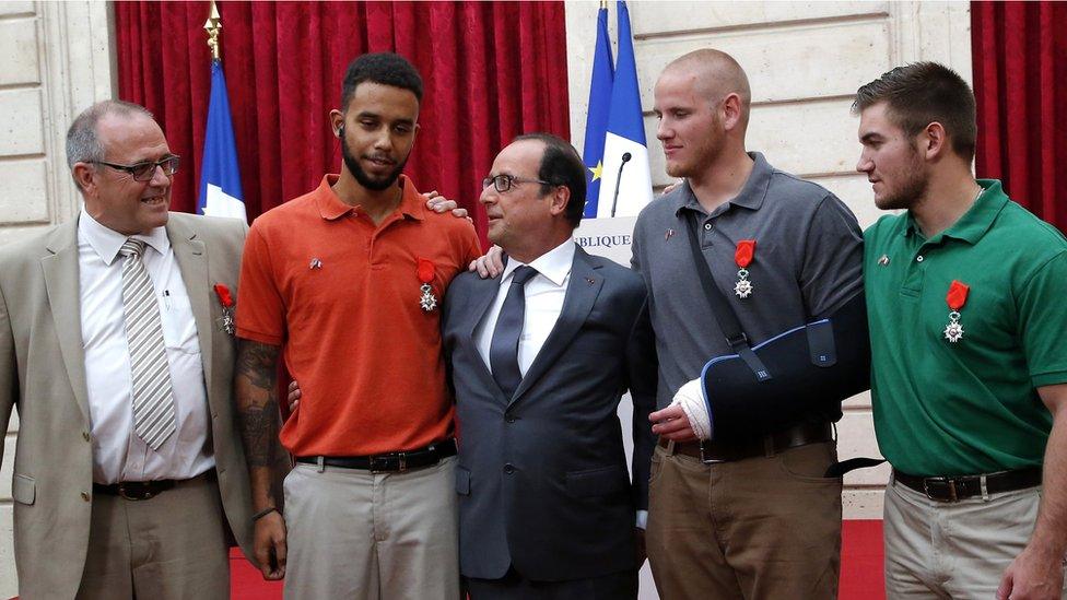 French President Francois Hollande poses with British businessman Chris Norman and Anthony Sadler from the US, and off-duty US servicemen Spencer Stone, and Alek Skarlatos during a reception in their honor at the Elysee Palace