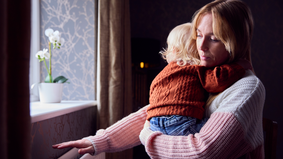 Woman with child at radiator