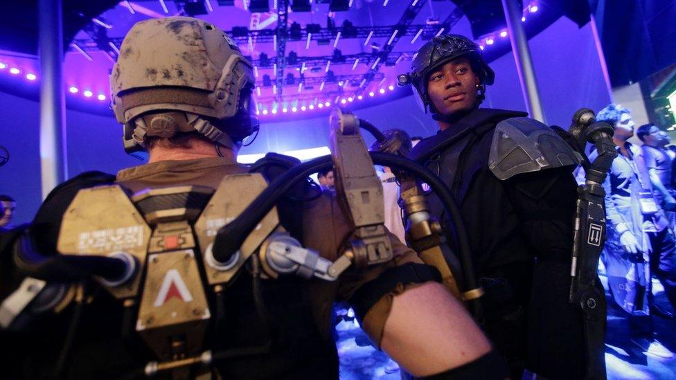 Models dressed as characters from the video game "Call of Duty" stand at the Activision booth at an expo, in Los Angeles