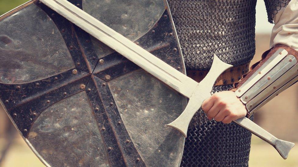 Man holding sword and shield