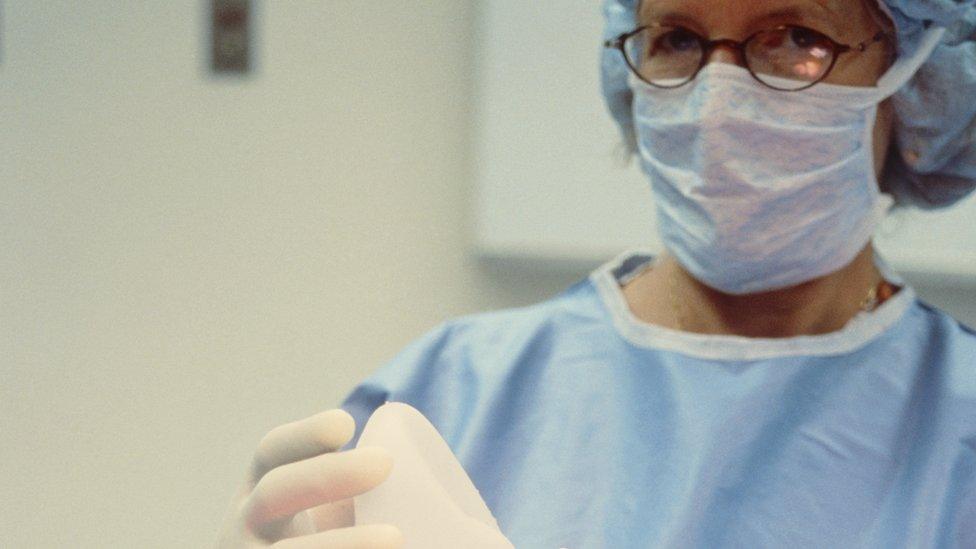 Surgeon holding a breast implant before breast surgery (mammoplasty) for breast augmentation