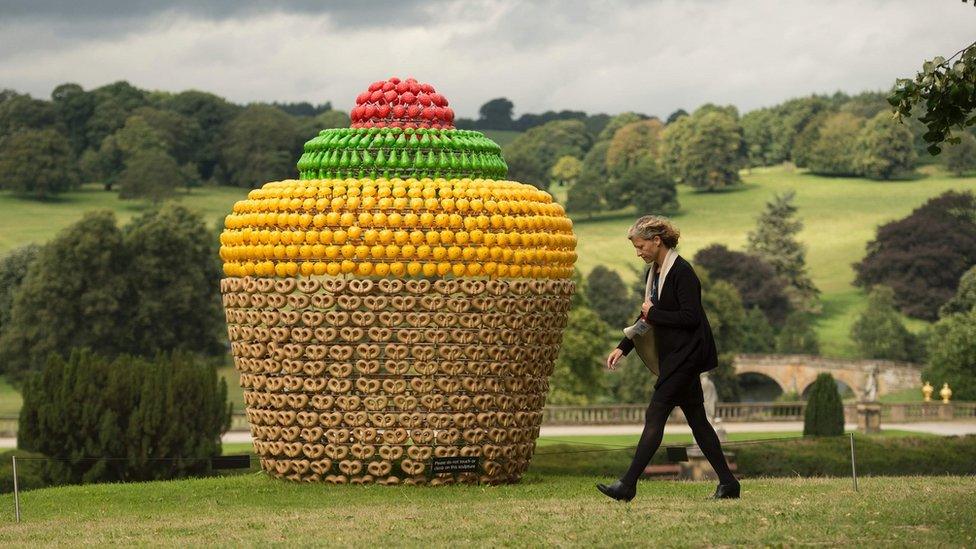 A woman walks past Portuguese artist Joana Vasconcelos' sculpture called Fruitcake