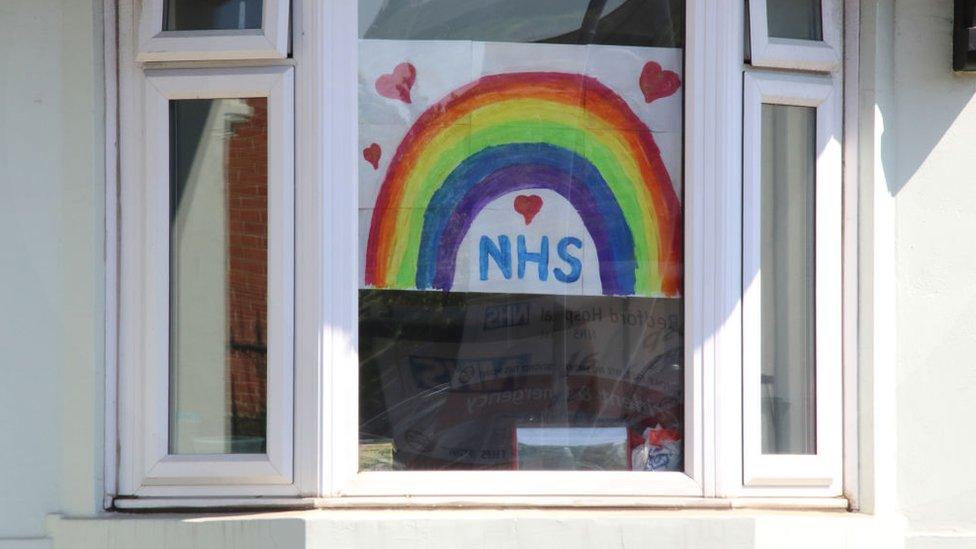 house with NHS sign in window