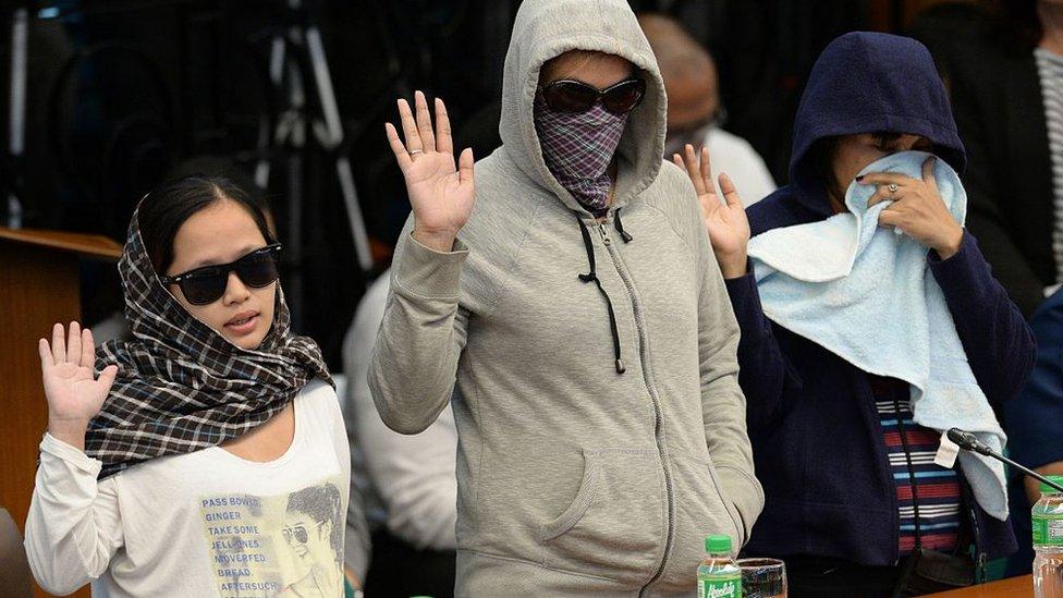 Harra Kazou (L), 26, and other witnesses take an oath at the start of a senate inquiry into a spate of extra judicial killings in Manila on August 22, 2016