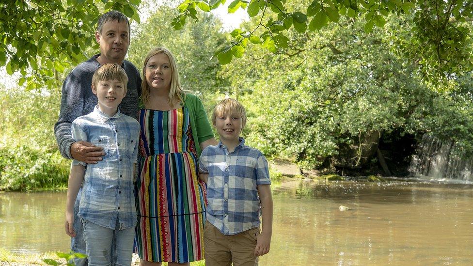 Donna and her family standing on a riverbank