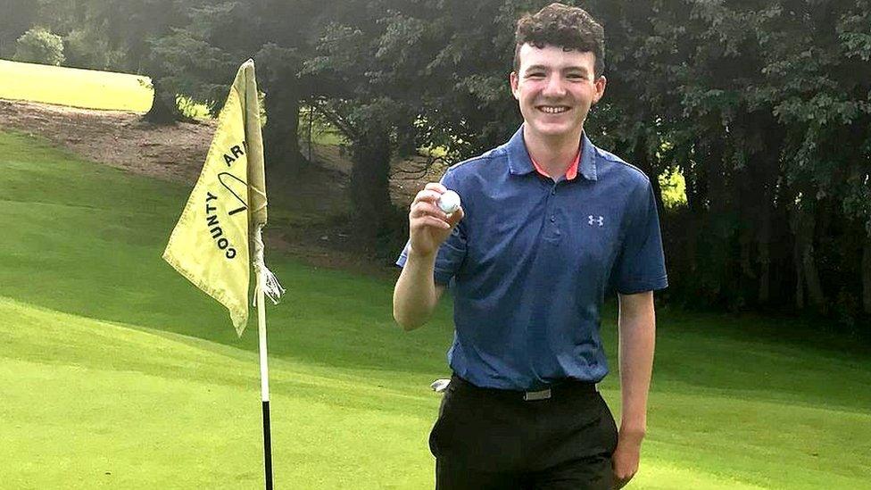 Joe Rooney holds his golf ball after scoring a hole-in-one