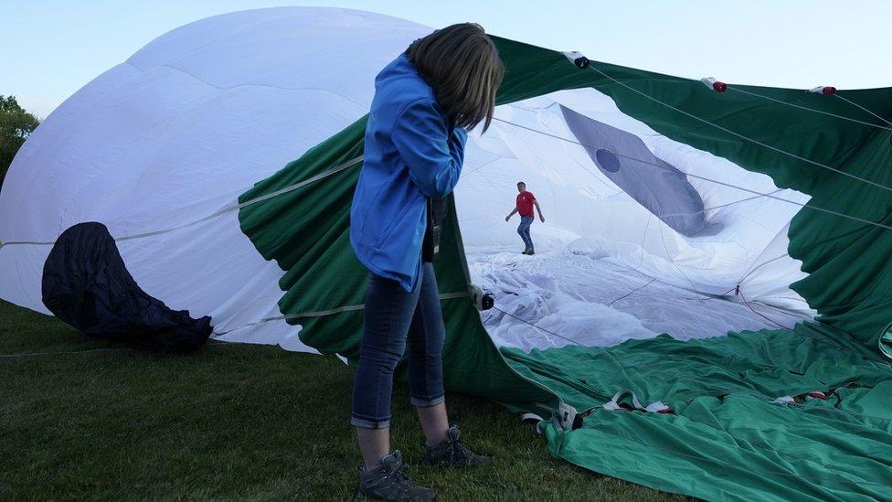 A man walking inside a deflated hot air balloon