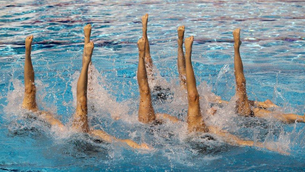 Artistic swimmers with their legs under the water