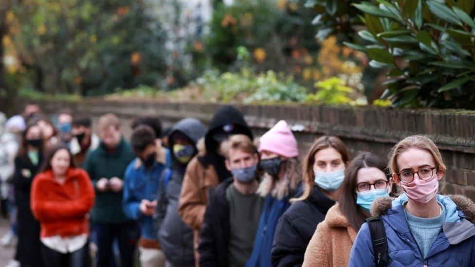 People lining up outside vaccination centre in London on 14 December 2021