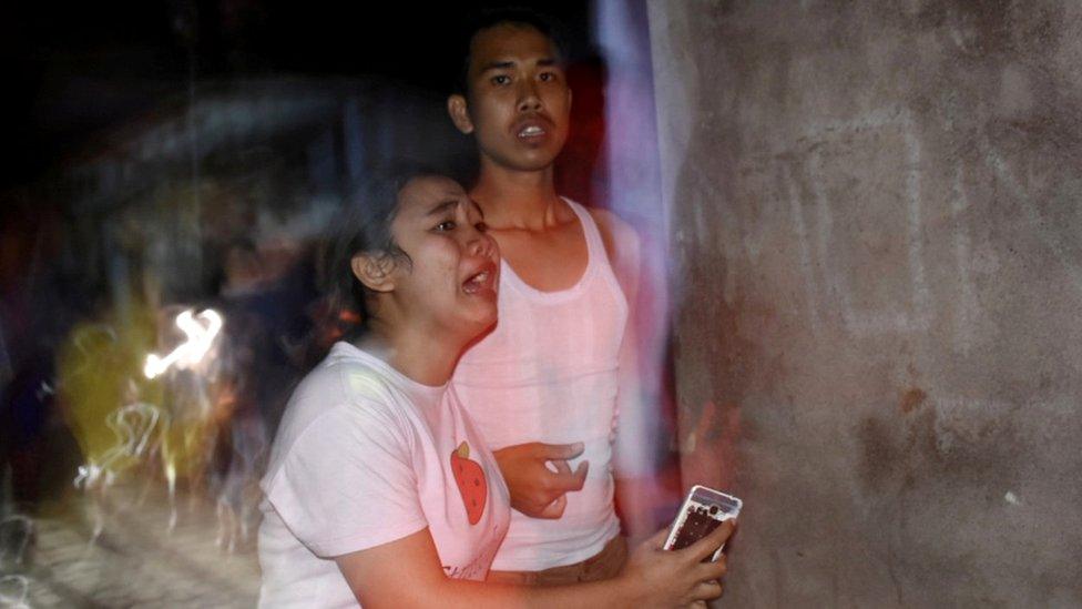 People react following an earthquake in Ampenan district, Mataram, Lombok,