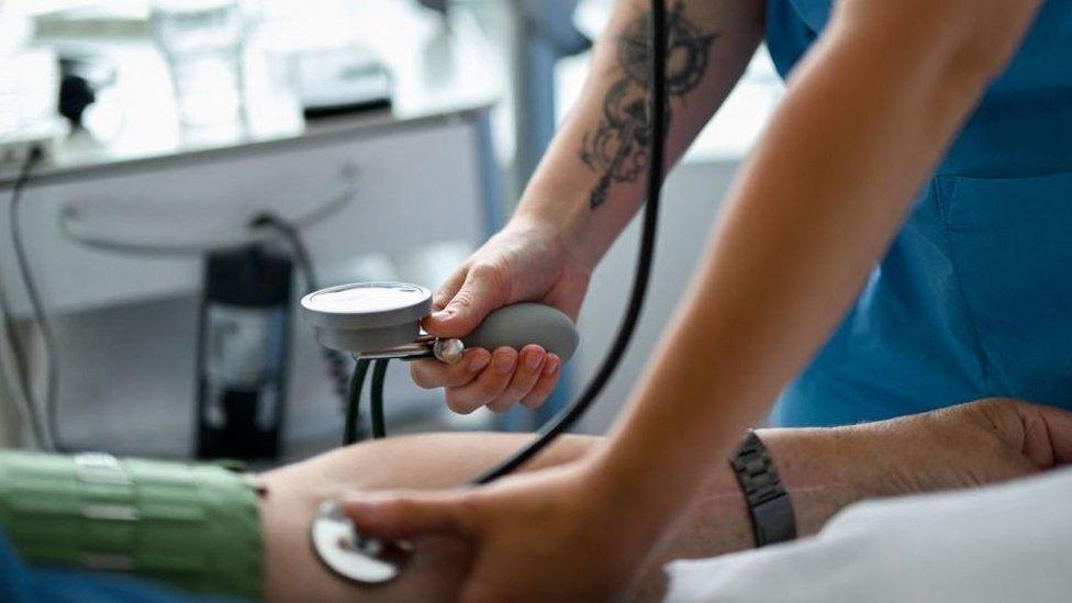 Nursing assistant 29-year Daria from Ukraine measures the blood pressure of a patient at the St. Johannes hospital in Dortmund, western Germany, on May 10, 2023