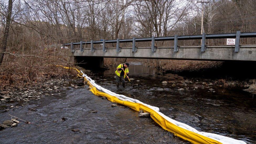 An Ohio EPA official inspects a waterway in East Palestine for signs of contamination.