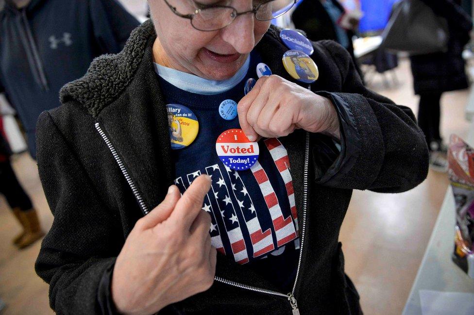 A voter puts on an "I voted" sticker