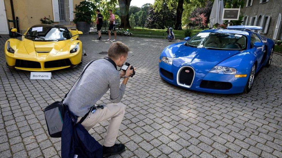 A picture taken on September 28, 2019 at the Bonmont Abbey in Cheserex, western Switzerland shows a 2015 Ferrari LaFerrari (L) and a 2010 Bugatti Veyron EB 16.4 Coupe model car during an auction preview by sales house Bonhams of sport cars belonging to the son of the Equatorial Guinea's President