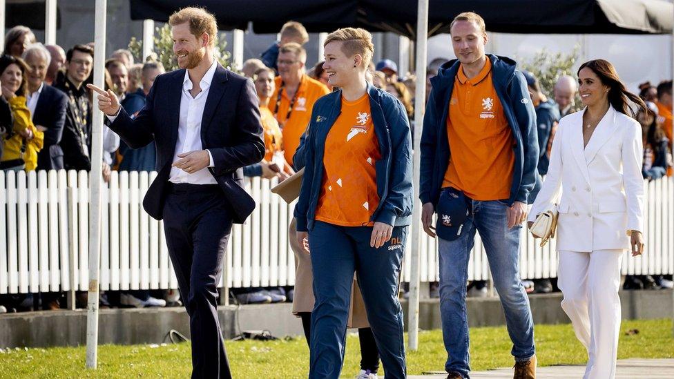 Prince Harry, Duke of Sussex (L) and his wife, Meghan, Duchess of Sussex (R) arrive on the Yellow Carpet before the start of the Invictus Games in The Hague