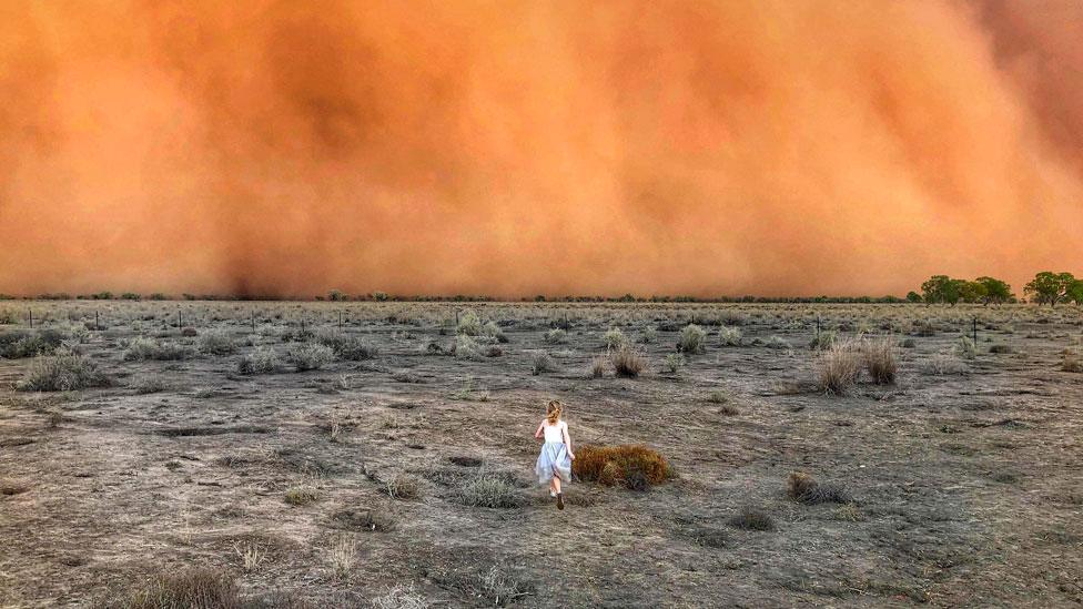 A child running towards a dust storm in Mullengudgery in New South Wales