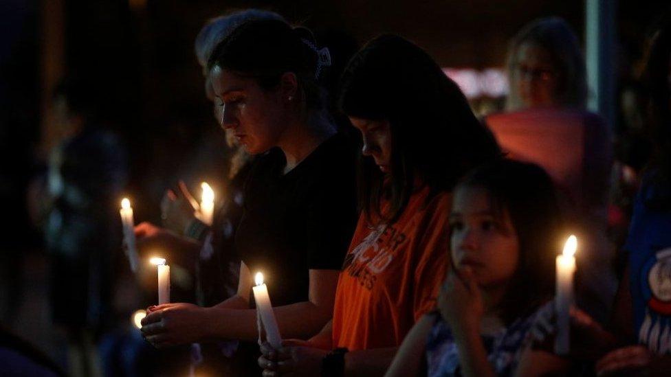 People hold candles during a vigil for the stabbing attack victims in Saskatchewan.