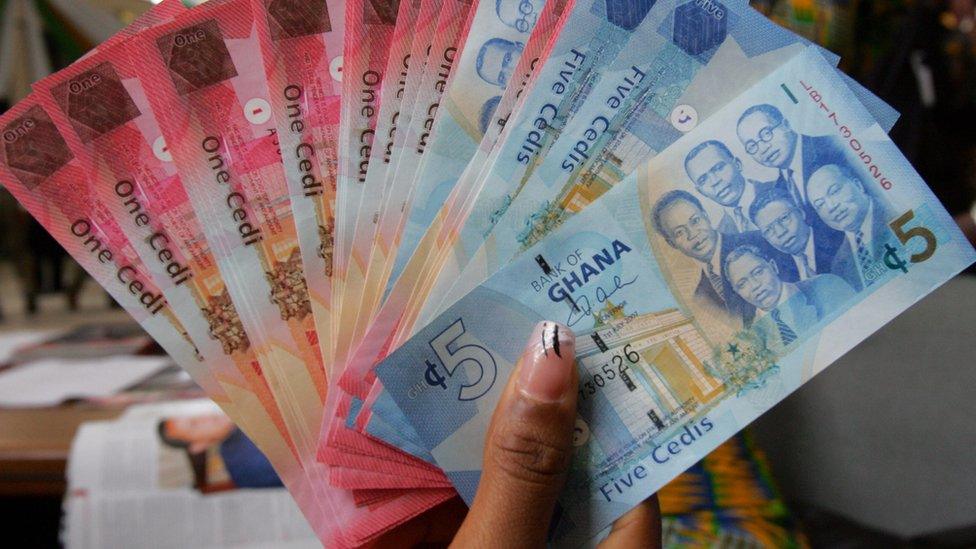 A woman holds on 3 July 2007 in Accra money