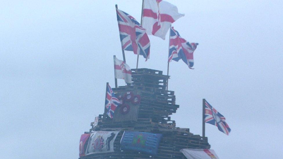 Flags and poppy wreaths on a bonfire in Creggan in 2023