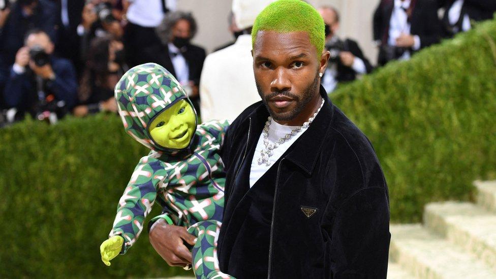 Frank Ocean carrying his green robotic doll