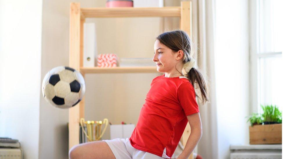 Girl playing football indoors