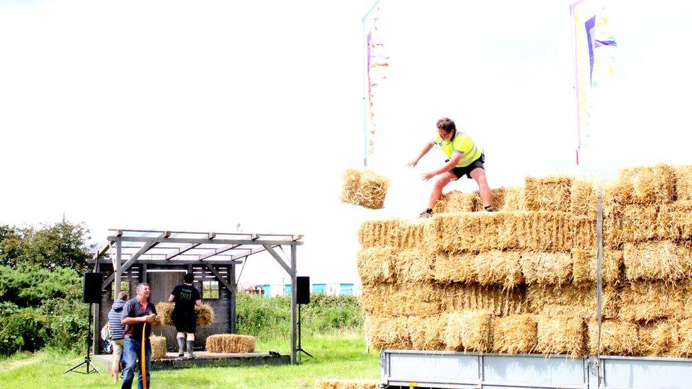 Seddau o wellt ar gyfer llwyfan y Llannerch // Offloading bales of hay that will become seats