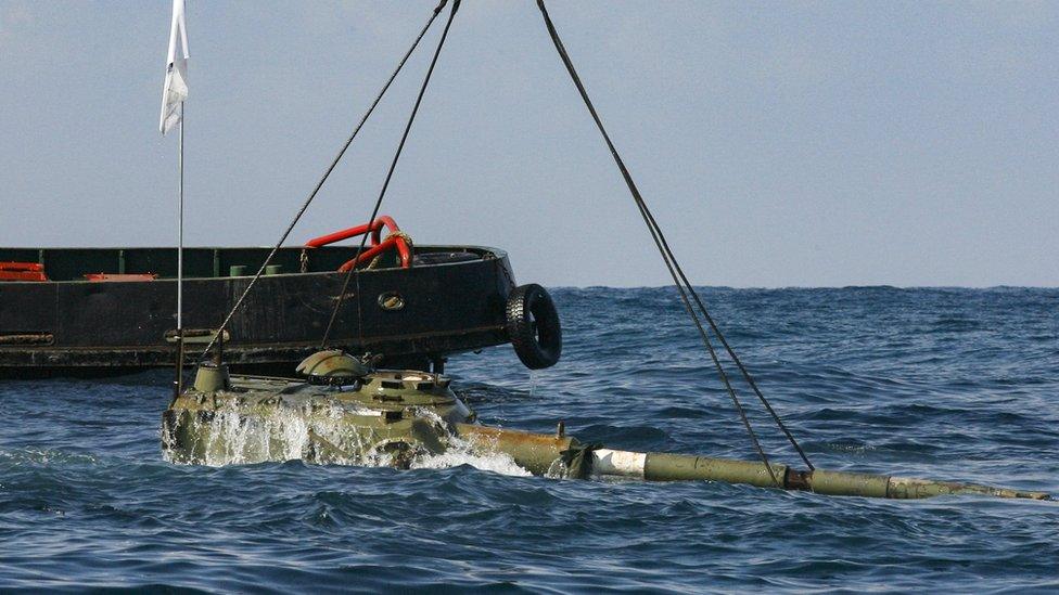 A tank disappears below the waves