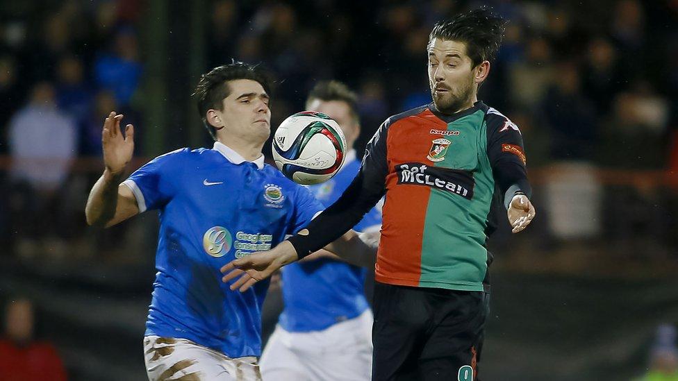 Linfield defender Jimmy Callacher battles for the ball with Curtis Allen of Glentoran during the Belfast derby clash at the Oval