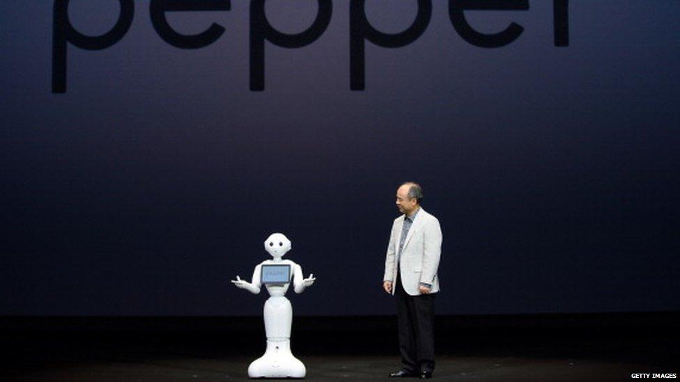 Masayoshi Son (R), president of Japan's mobile carrier SoftBank, introduces the humanoid robot 'Pepper'