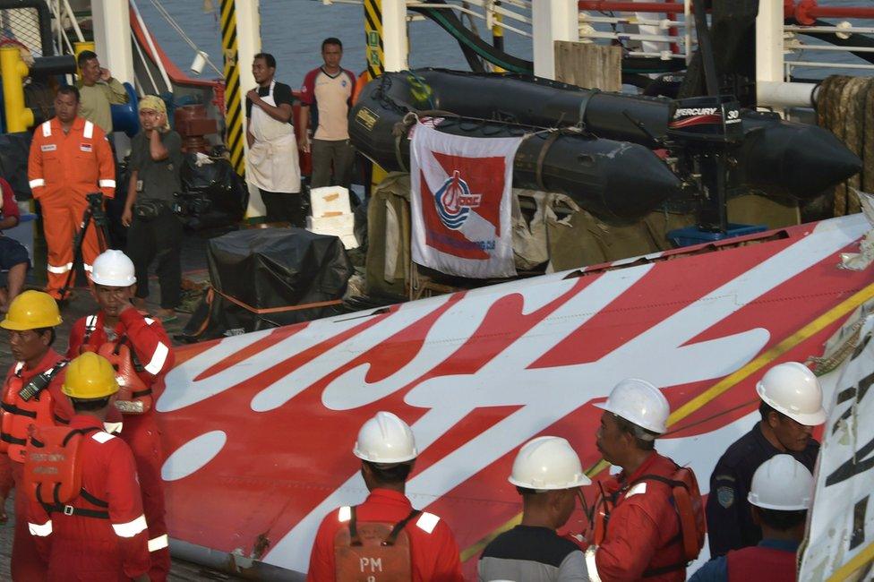 Indonesian crew of the Crest Onyx ship prepare to hoist recovered wreckage of AirAsia flight QZ8501 at port in Kumai on 11 January 2015