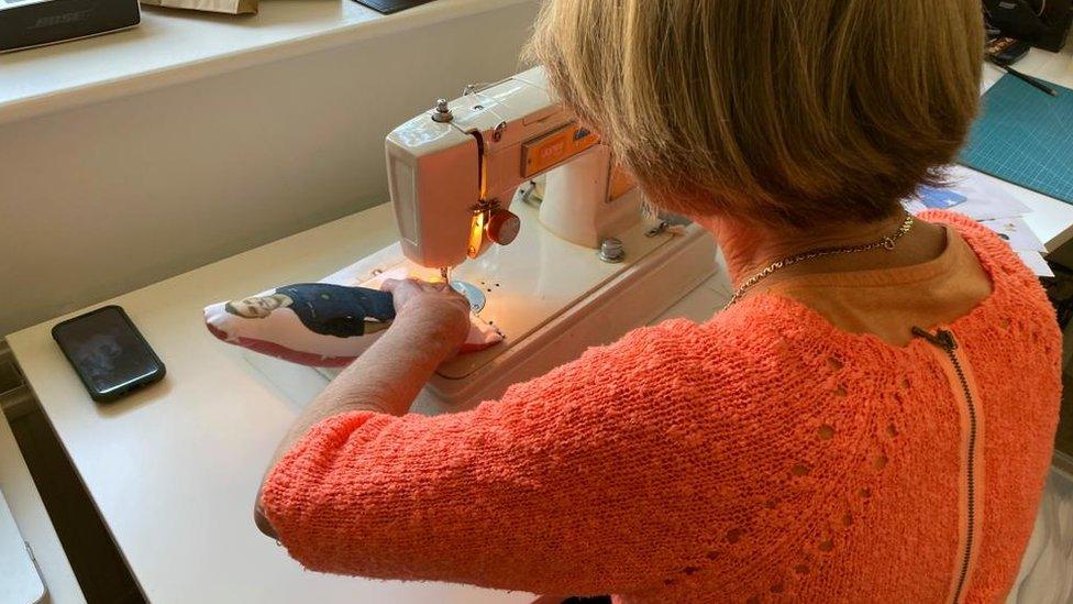 Julia Leadbetter sewing a huggable hero toy that she is making on a sewing machine