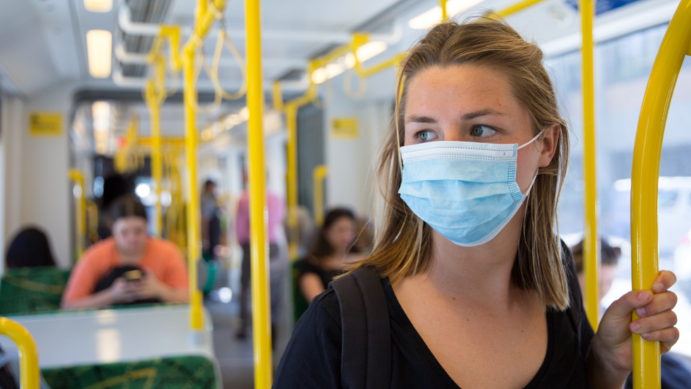 person on public transport wearing mask